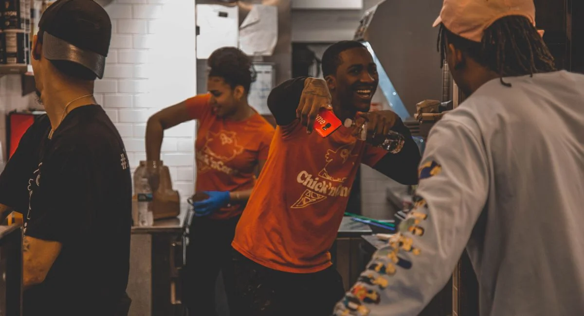 Energetic restaurant staff working together in a kitchen, showing teamwork and joy.