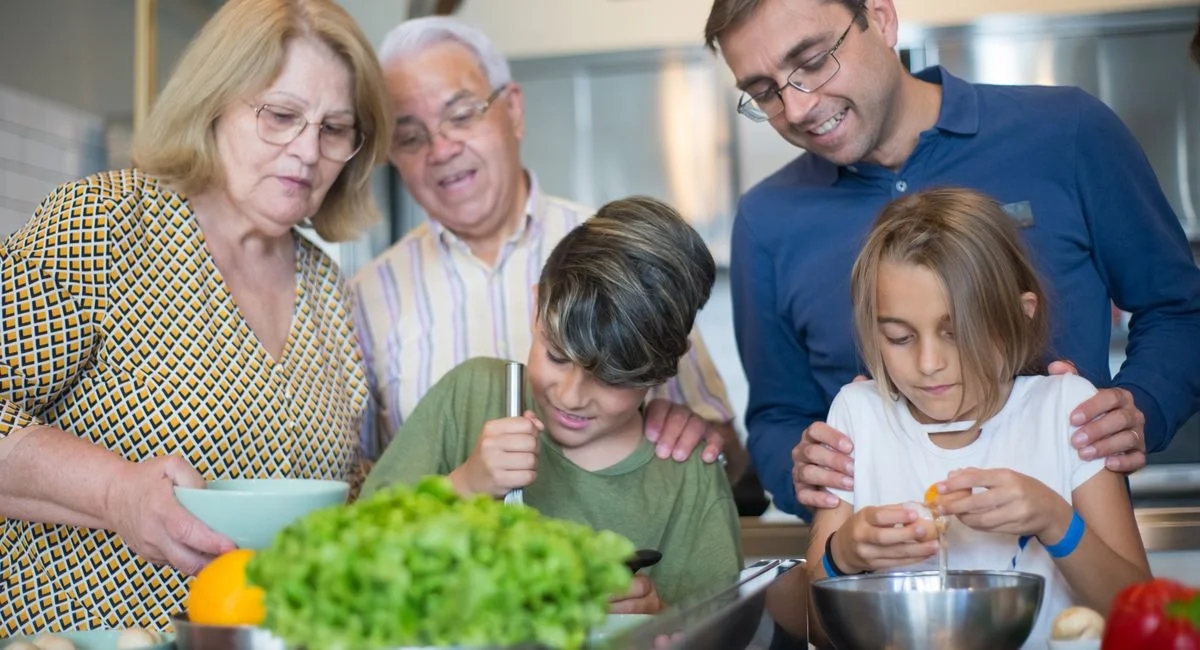 A joyful multi-generational family bonding while preparing a meal in the kitchen.