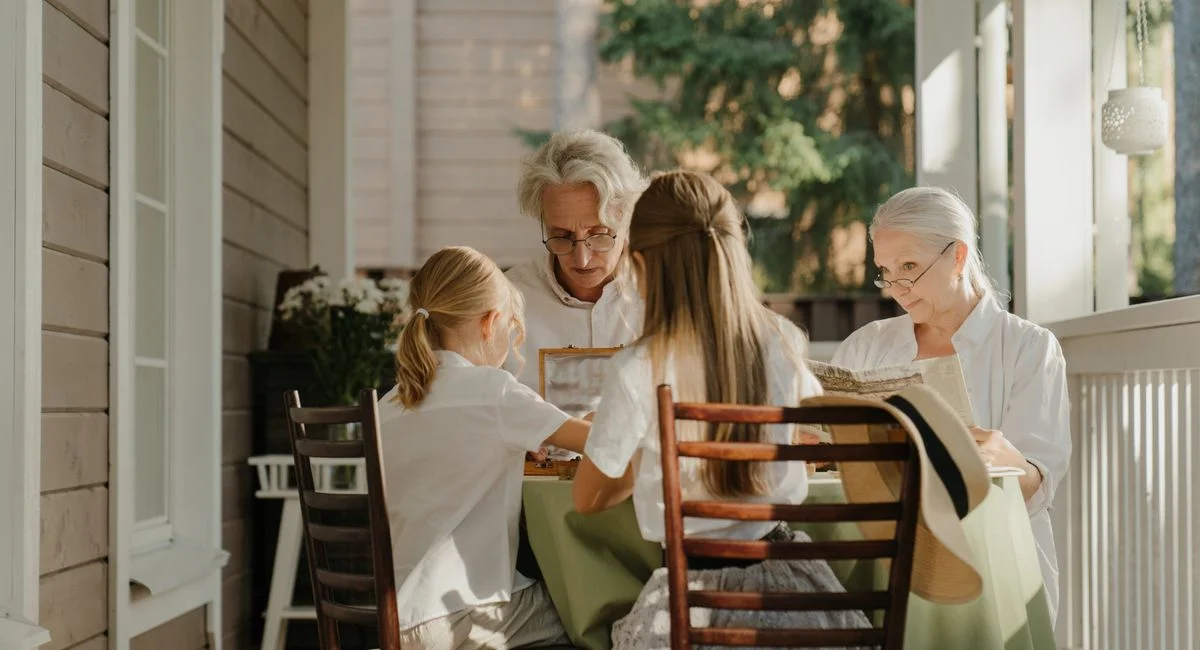Multi-generational family sharing a moment on a sunlit veranda, capturing togetherness.