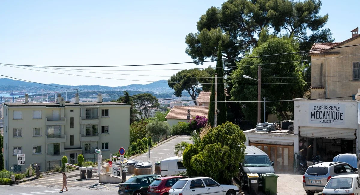 Charming street scene in Toulon, France, capturing buildings and nature under clear blue skies.