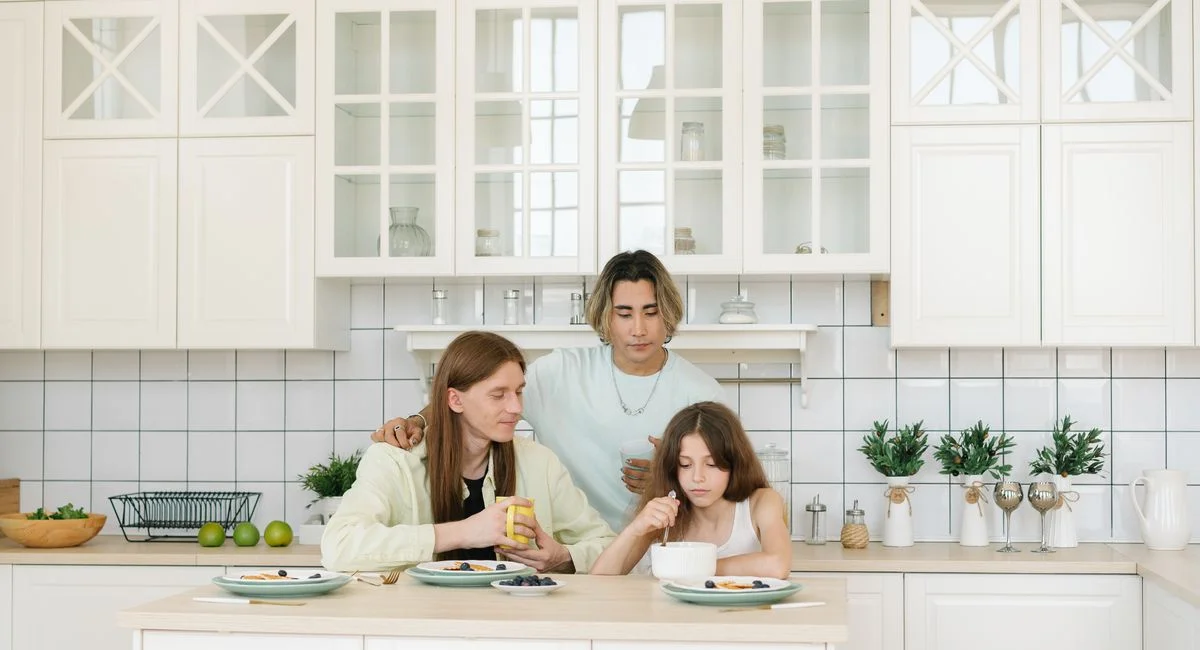 A diverse family having breakfast together in a bright, modern kitchen.