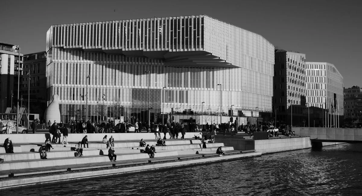 Black and white photo of Deichman Library on Oslo waterfront, showcasing its modern design.