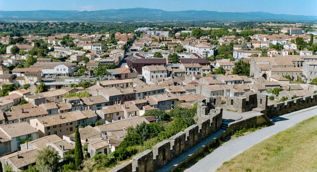 Aerial view of the historic walls and rooftops of Carcassonne, Occitanie, France on a sunny day.