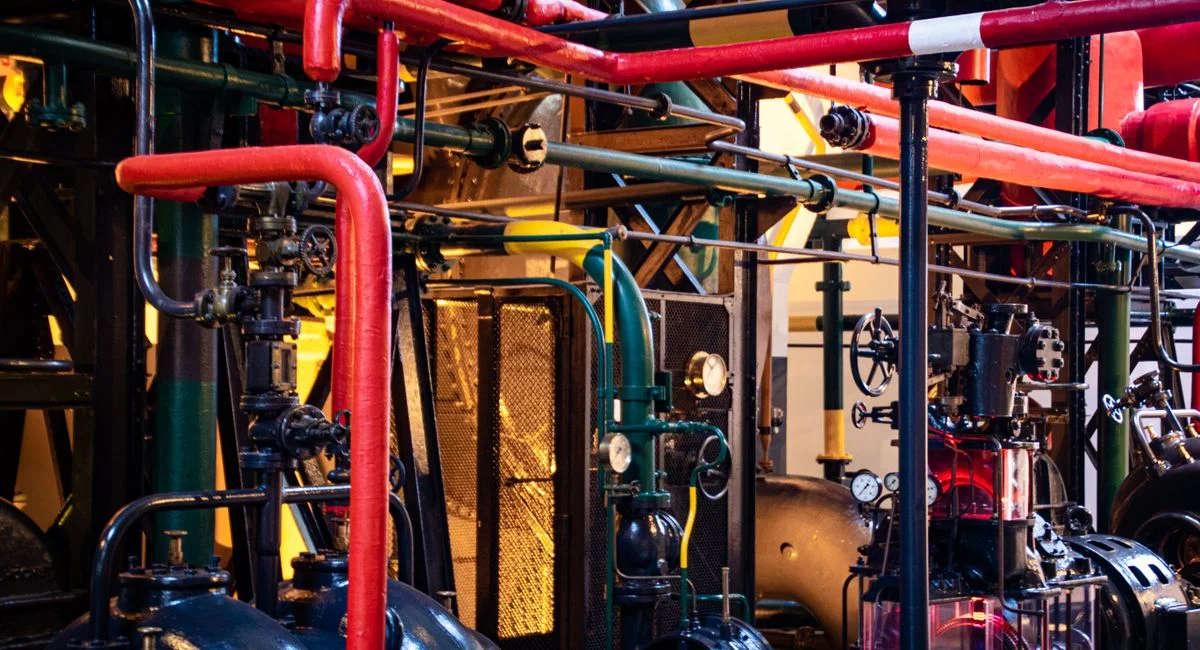 Complex network of industrial pipes and machinery inside a Lisbon plant.
