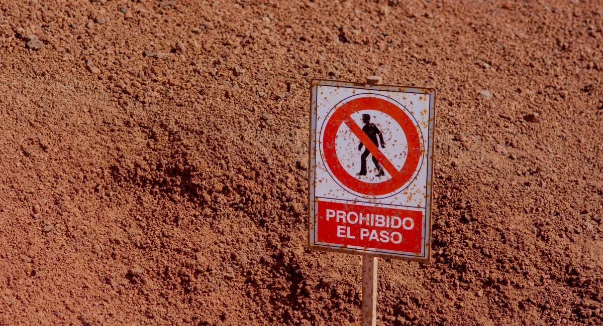 Warning sign 'Prohibido El Paso' in the arid landscape of Lanzarote, Spain. No trespassing.