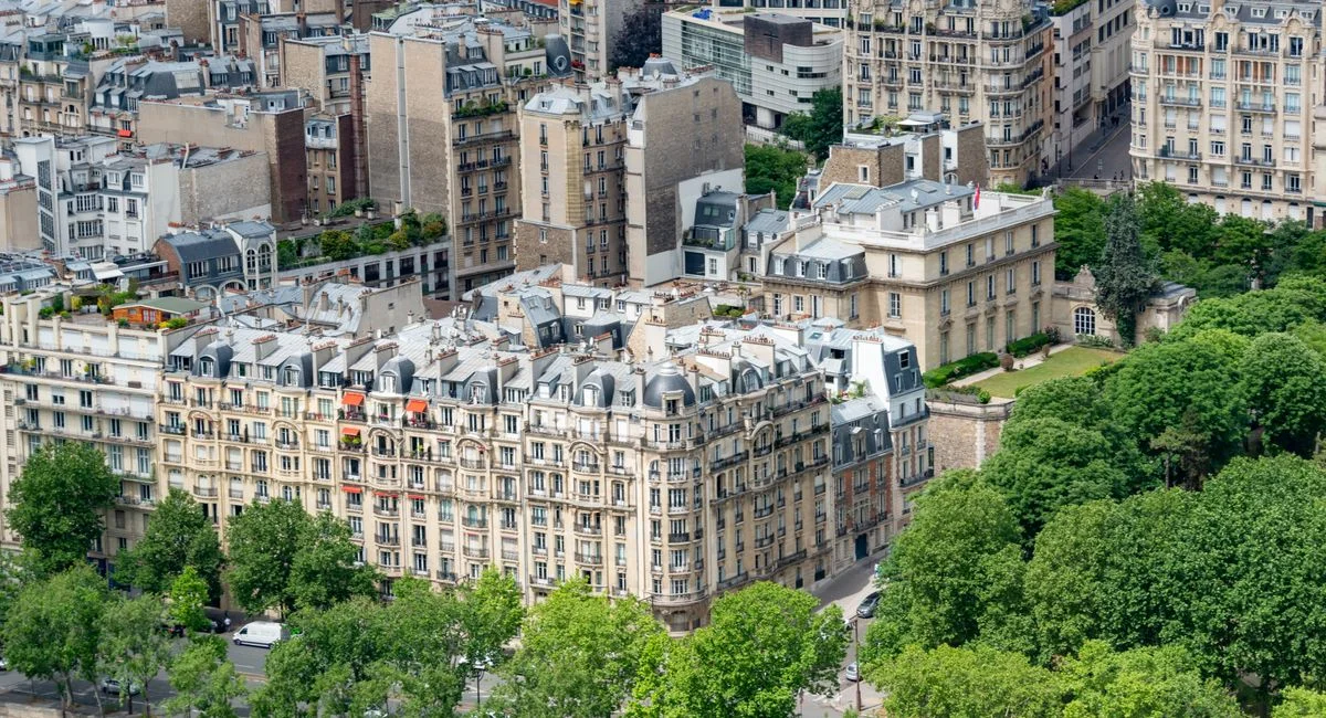 Aerial photo capturing classic Parisian residential architecture in a green urban setting.