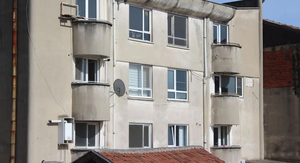 Close-up of an urban apartment building exterior with balconies and windows.
