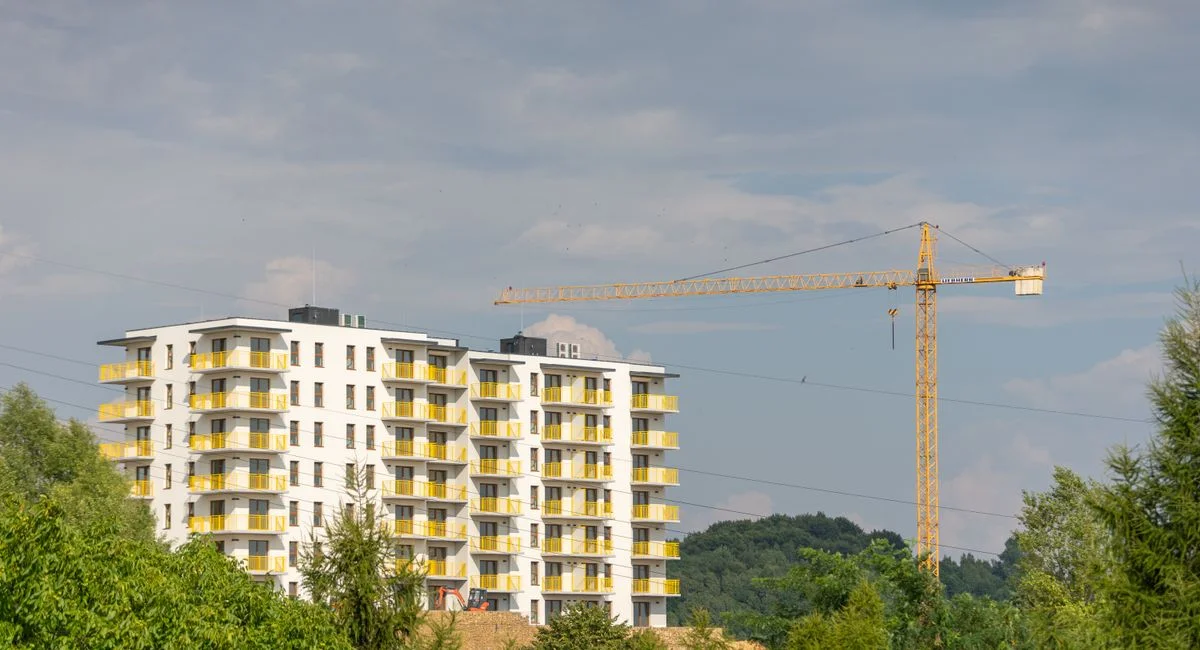 View of modern apartment building and construction crane in Trzebinia, Poland.
